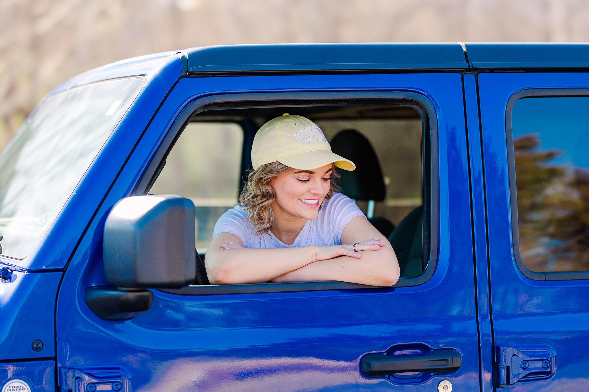 young woman leaning out jeep window