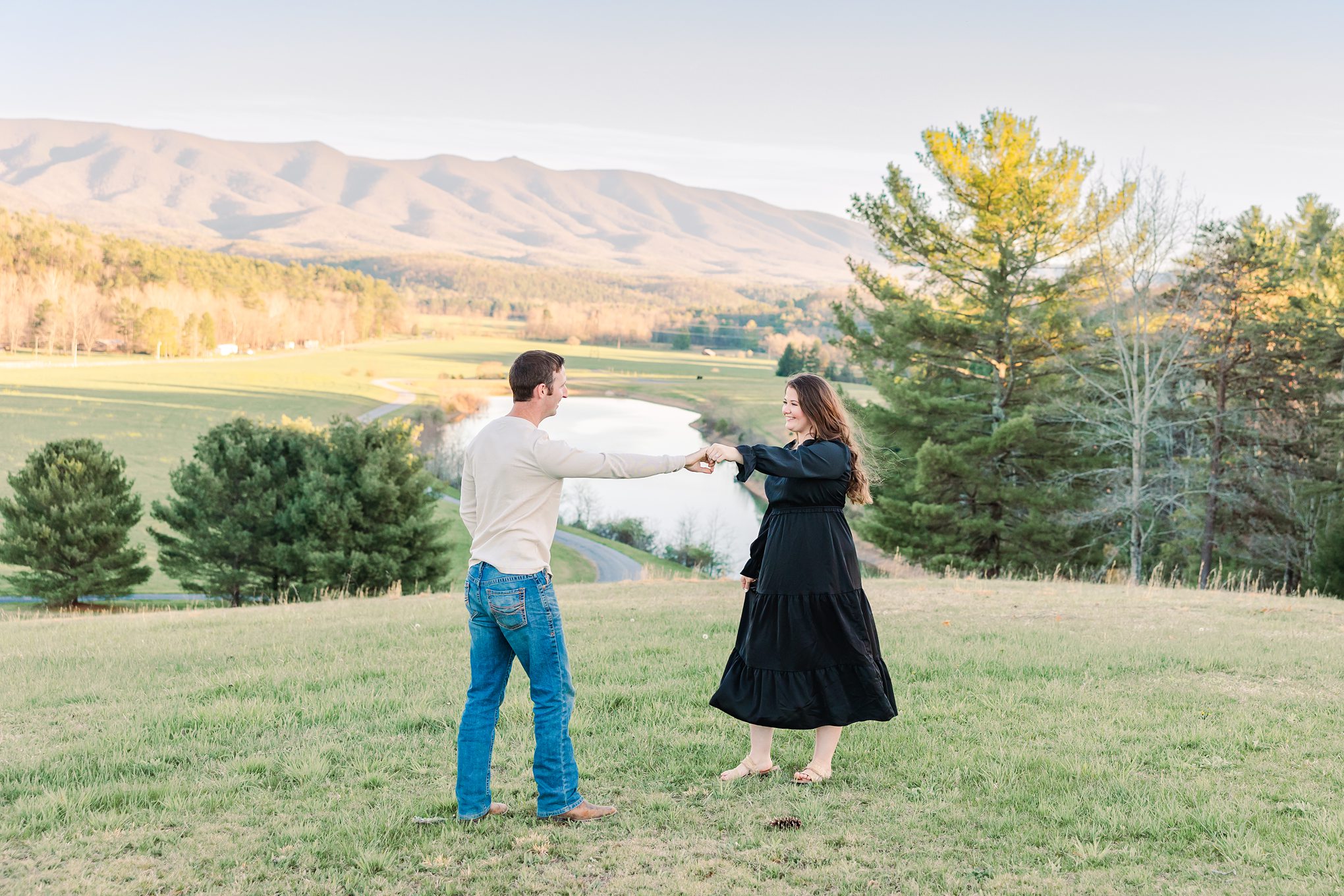 engaged couple twirling with mountains in background